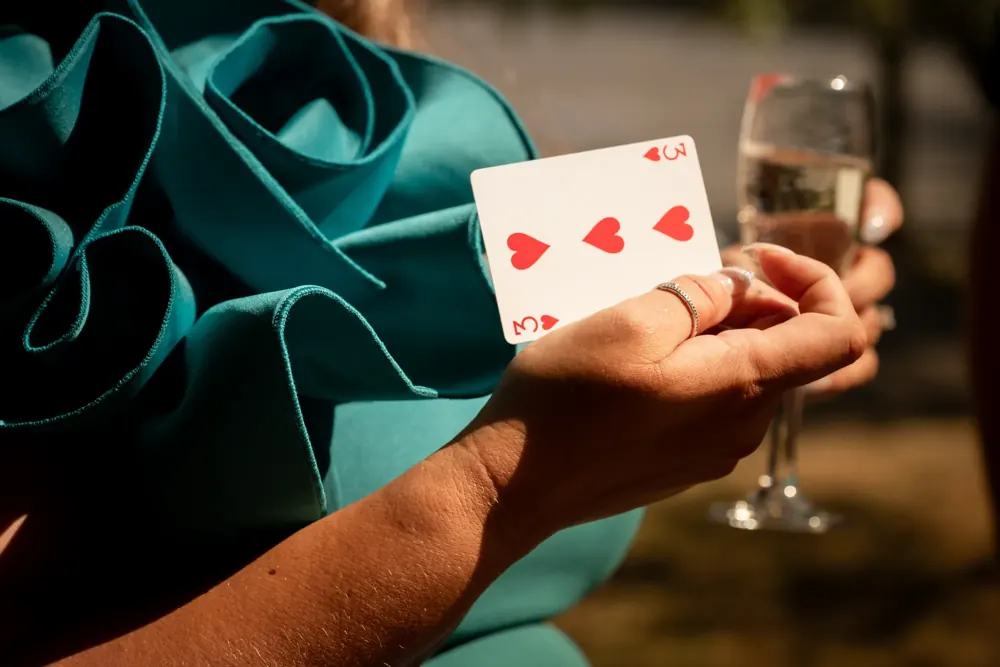 A guest holding her signed playing card