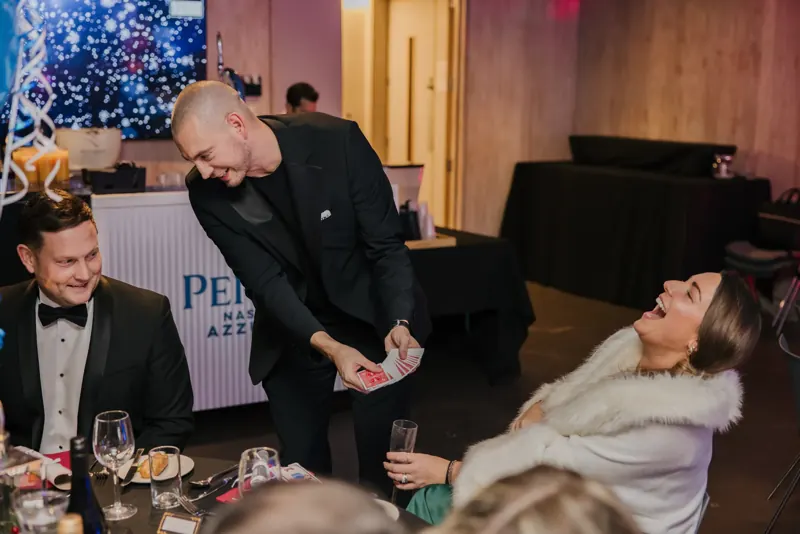 A guest laughing at a black-tie dinner