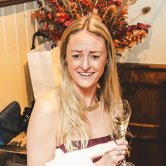 A guest smiling at Matt Parrou2019s magic at a festive party