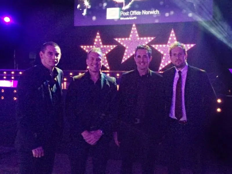 A team of four magicians on stage at an awards night
