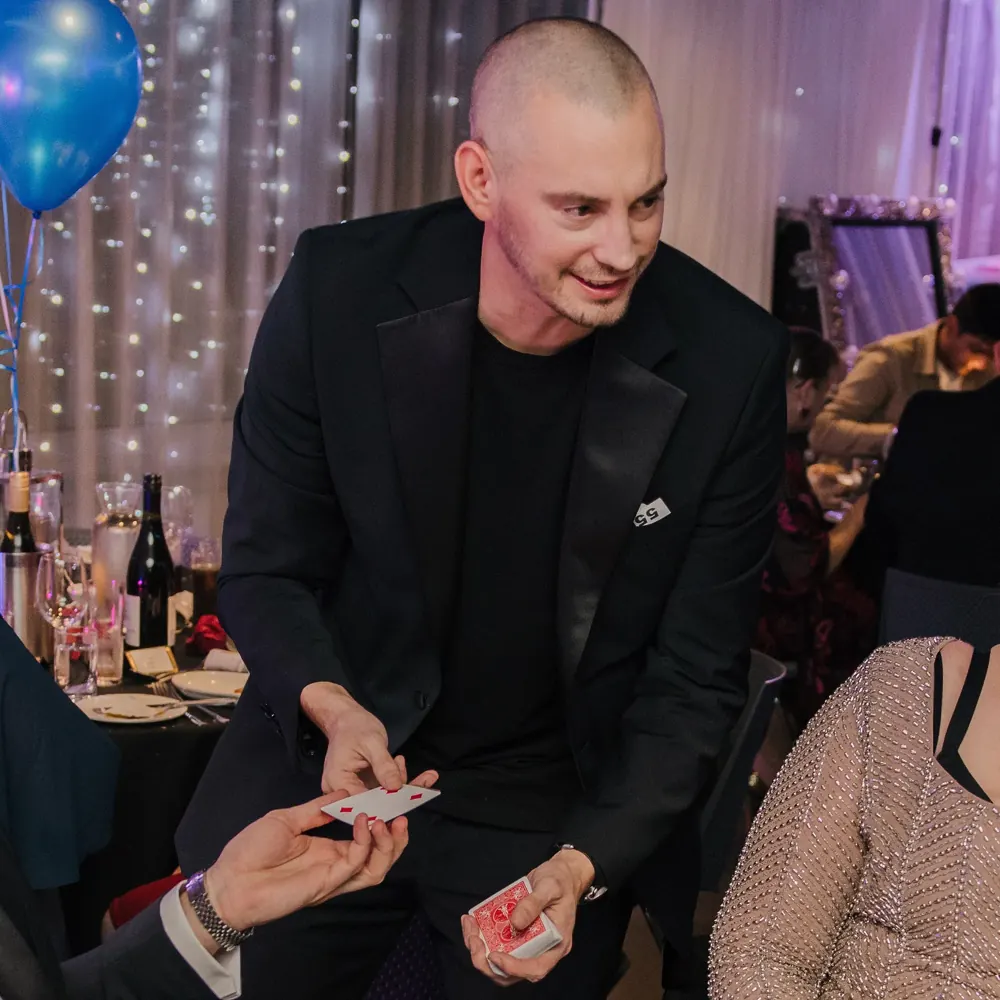 Dorset magician Matt Parro performing a card trick for party guests
