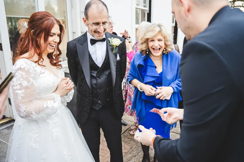 Bride, groom and mother amazed by a magic trick