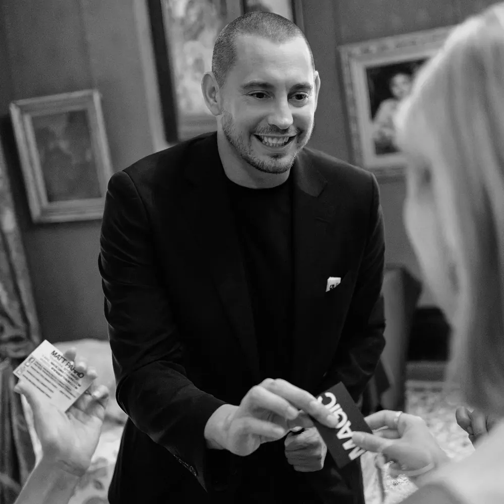 Close-up magician Matt Parro performing a card trick, black and white