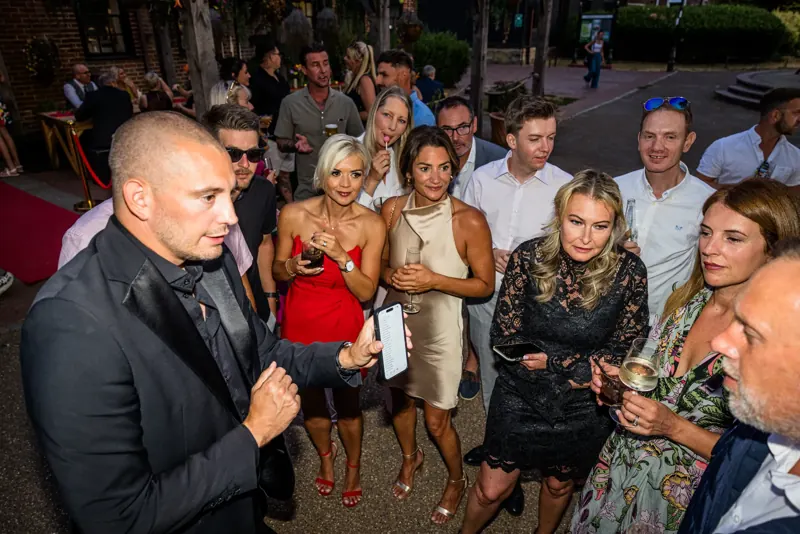 Crowd watching Matt Parro at a summer garden party
