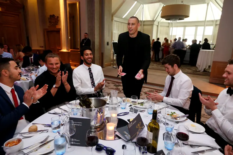 Dinner guests applauding Matt Parrou2019s table magic
