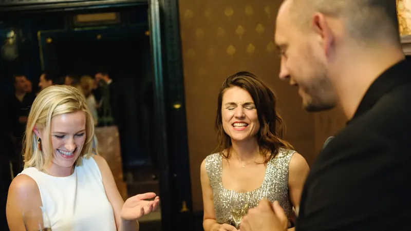 Elegant guests amazed by Matt Parrou2019s card trick