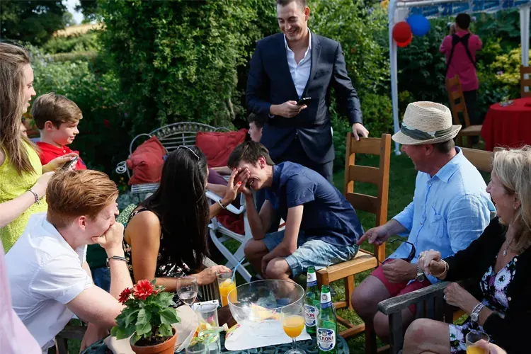 Family guests watching Matt Parro at a garden party