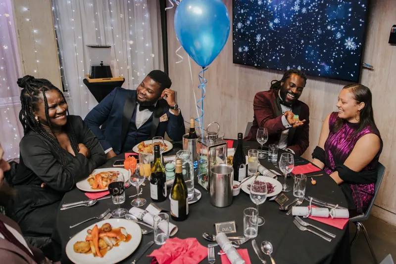 Gala table guests laughing at Matt Parrou2019s magic