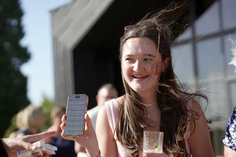 Guest smiling at a phone reveal during Matt Parrou2019s digital magic