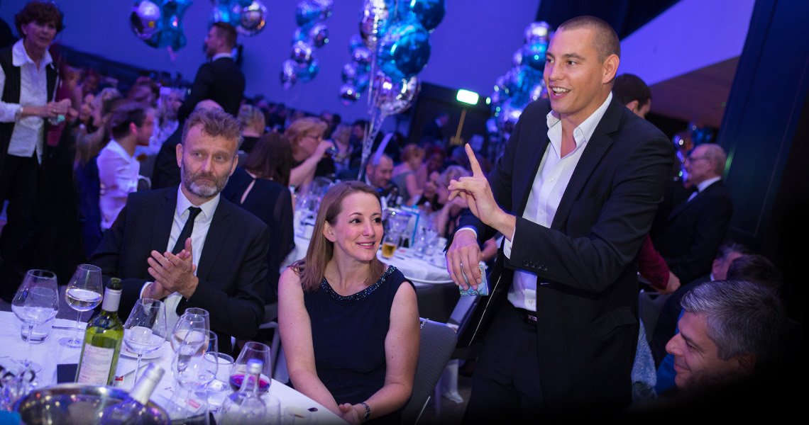 Guests applauding Matt Parro at a corporate dinner
