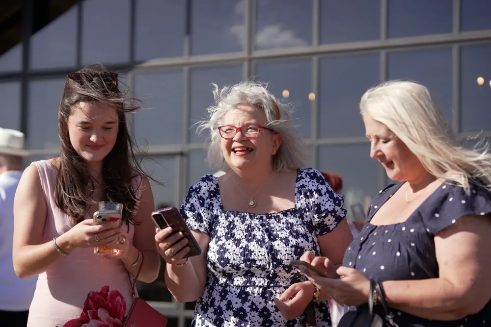 Guests checking their phones after a mind-reading trick at a corporate event