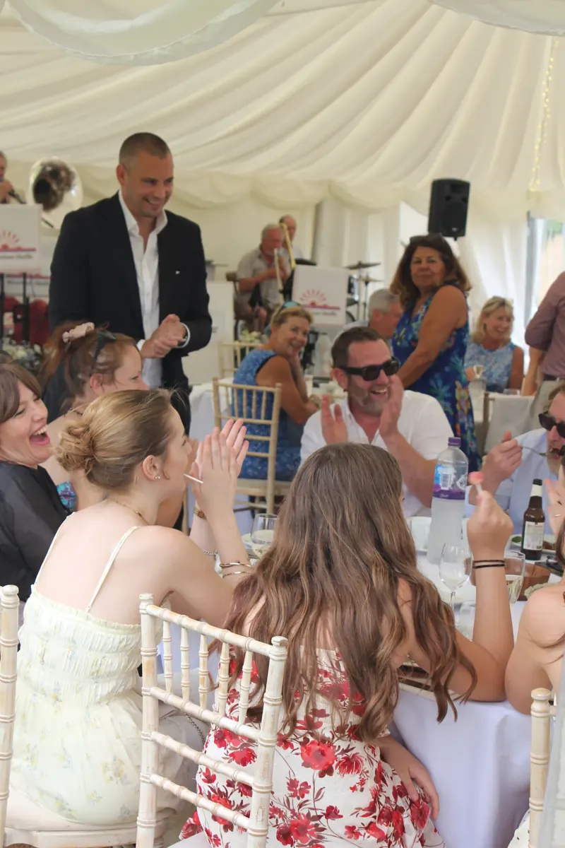 Guests clapping Matt Parrou2019s magic in a marquee