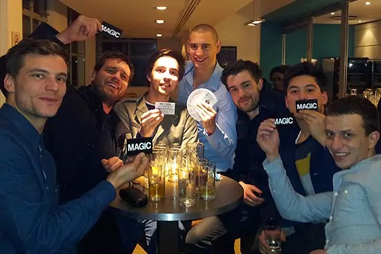 Guests holding Matt Parro magic cards after a performance