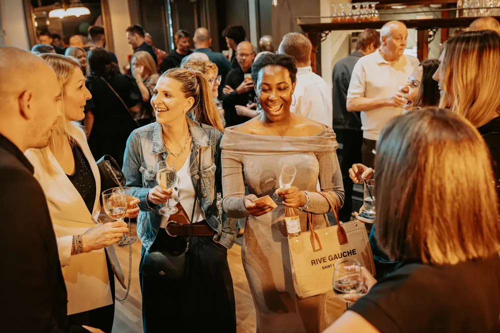 Guests laughing at a card trick during a magic show for adults