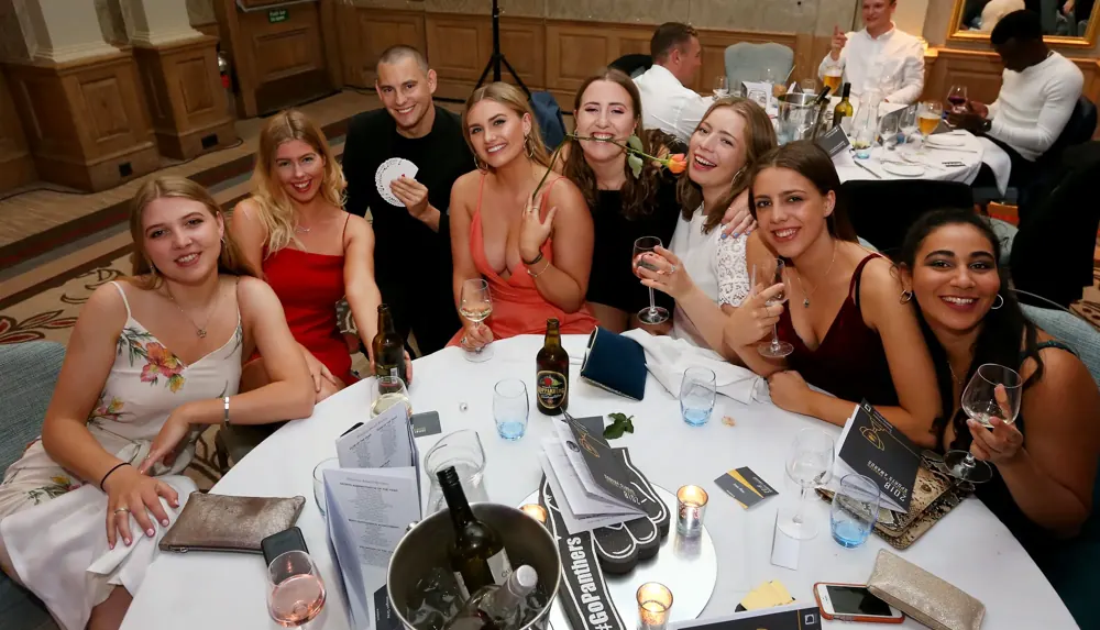 Guests laughing at table magic during a ball