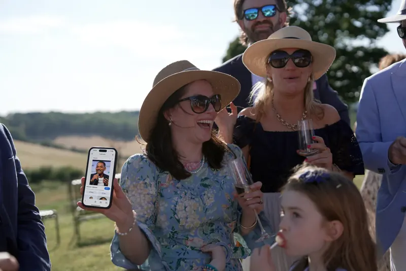 Guests reacting to Matt Parrou2019s iPhone magic at a Surrey corporate summer party
