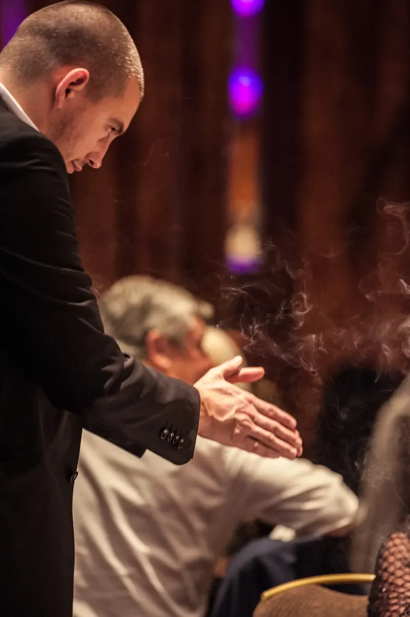 Matt Parro performing a smoke trick for a dinner guest