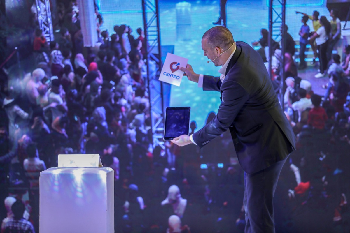 Matt Parro performing iPad magic on stage in front of a live audience