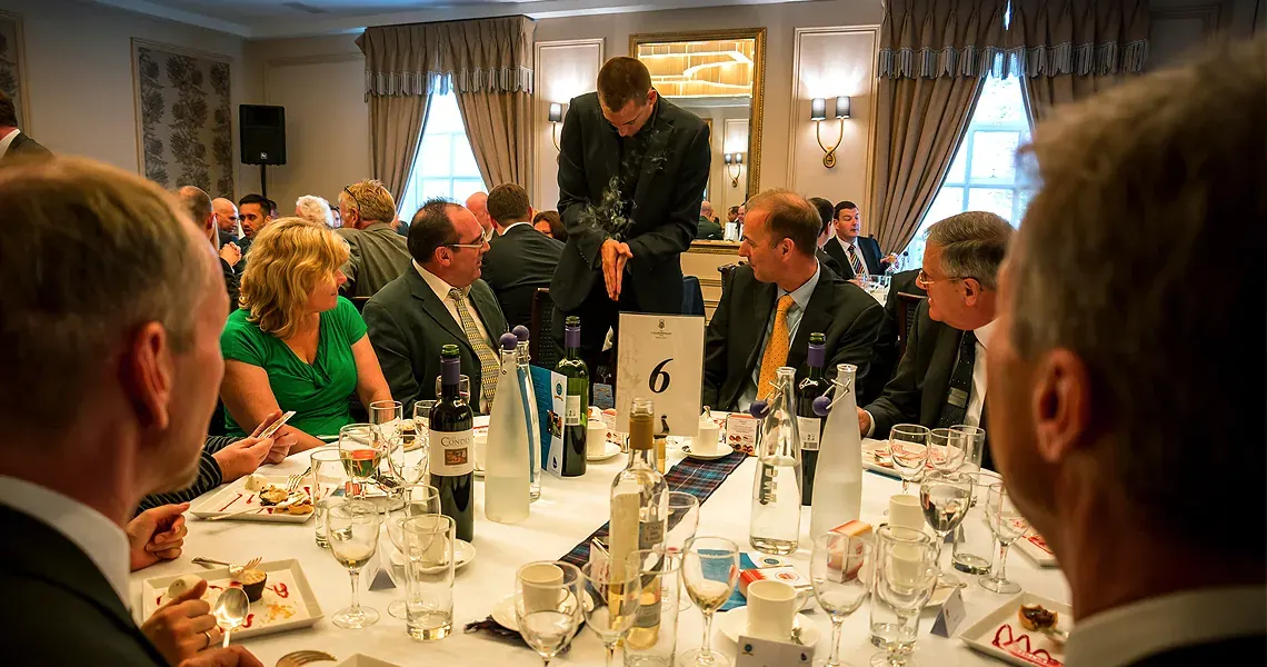 Matt Parro performing table magic for guests at a hotel Christmas dinner