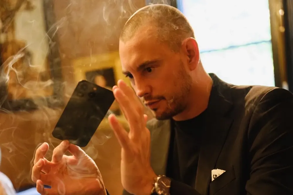 Matt Parro pushing a phone through a glass