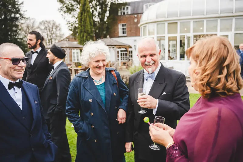 Older wedding guests laughing at magic in the garden