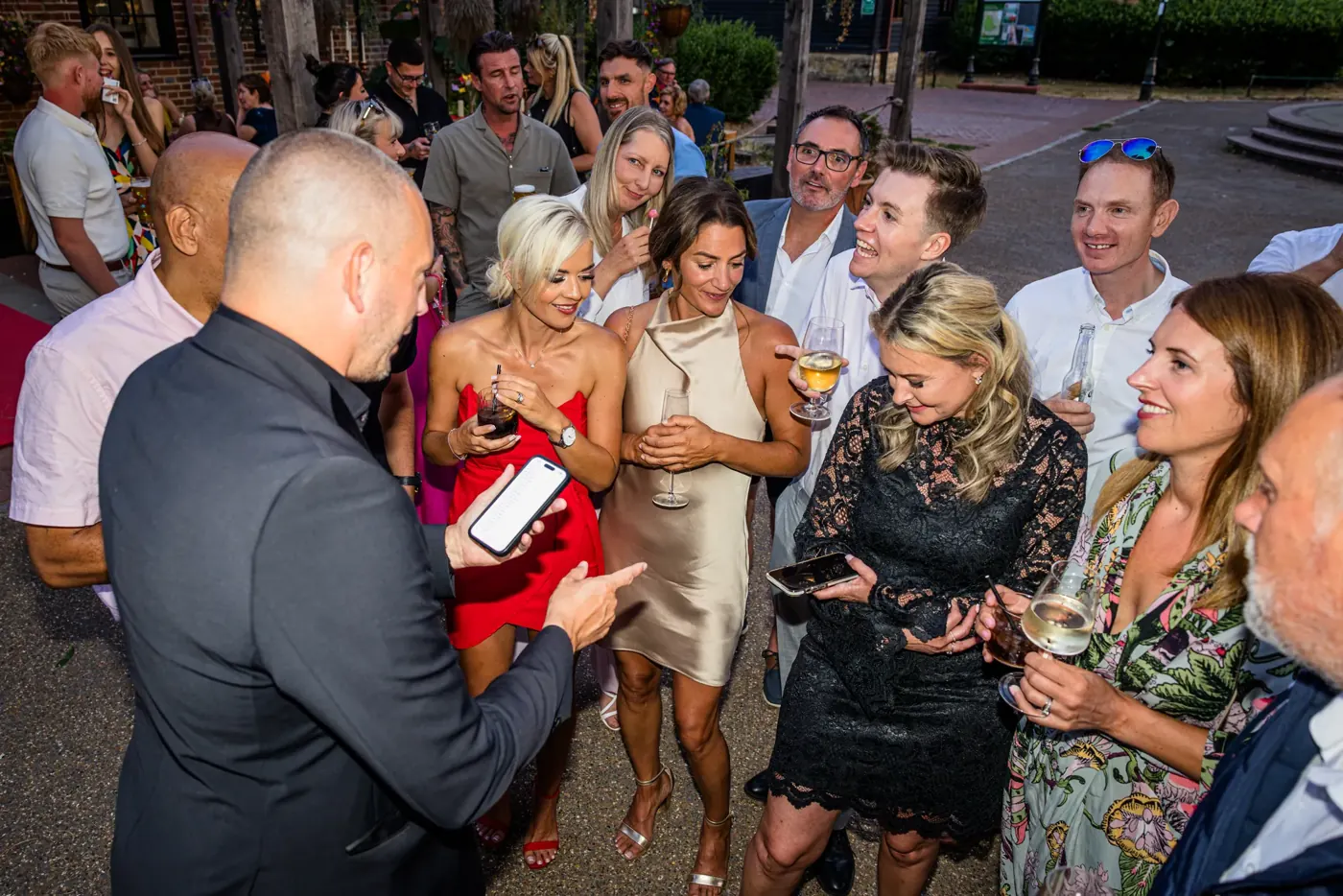 Party guests reacting to party magician Matt Parro at an evening party