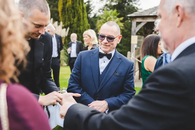Wedding guests amazed by a ring trick in the garden